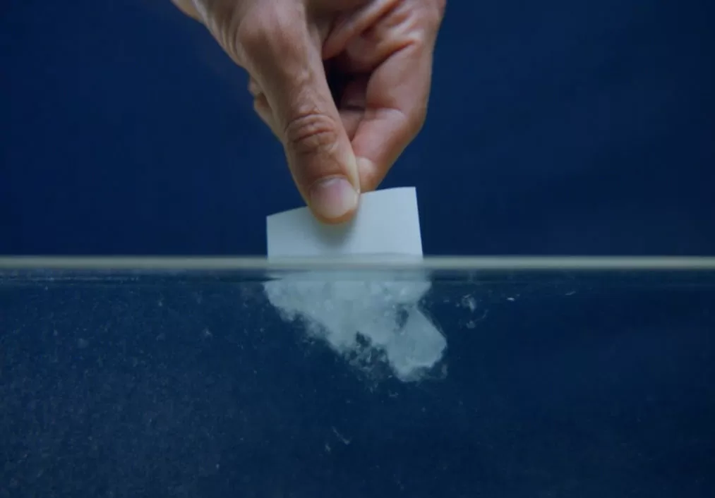 hand dipping dissolving white label in water